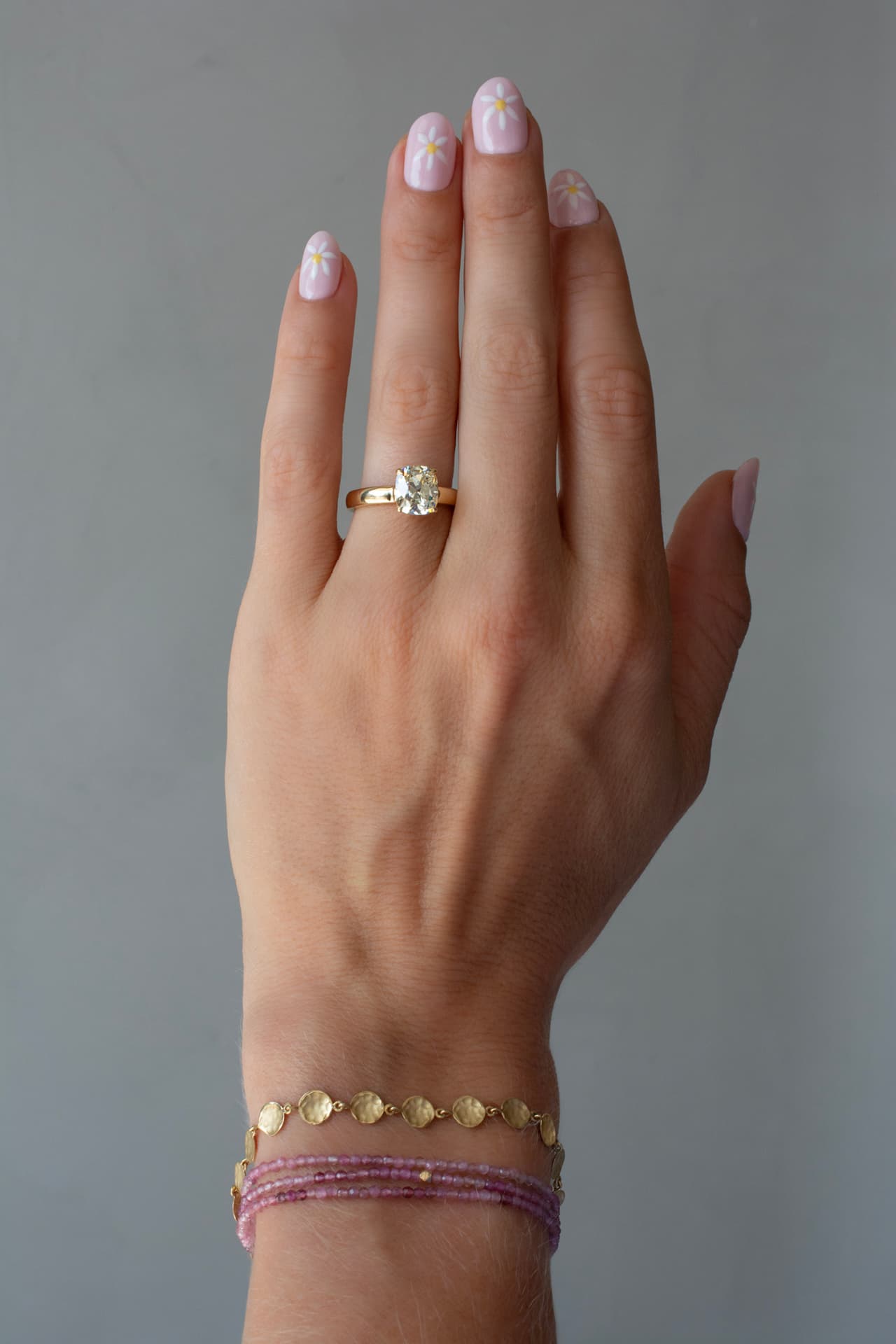 Diamond ring and pink gemstone wrap bracelets worn on the hand