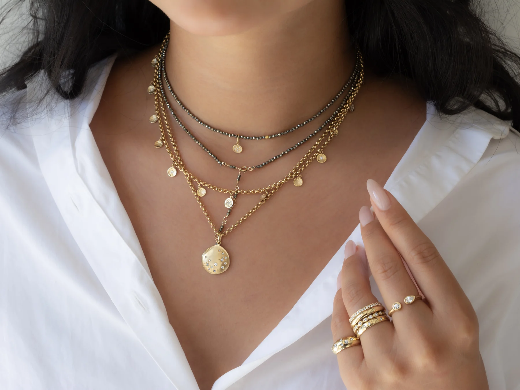 Layered gemstone wraps, gold charms and rings